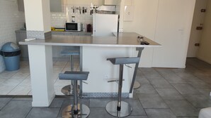 A modern kitchen with a central island, bar stools, a microwave, and a coffee maker. - Just a short walk from Avignon's historic center, a quiet apartment, (Avignon)