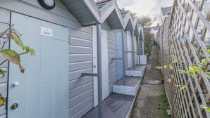 En rad låga byggnader, alla i en våning, med en liten veranda och en dörr där det står ”1 Onan”.