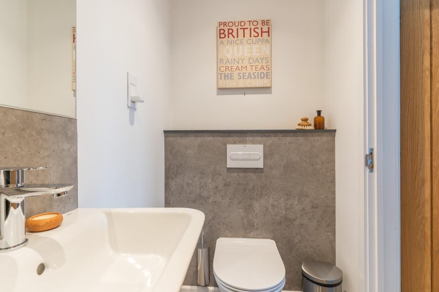 Une salle de bain équipée d’une baignoire, de toilettes et d’un interrupteur fixé au mur.