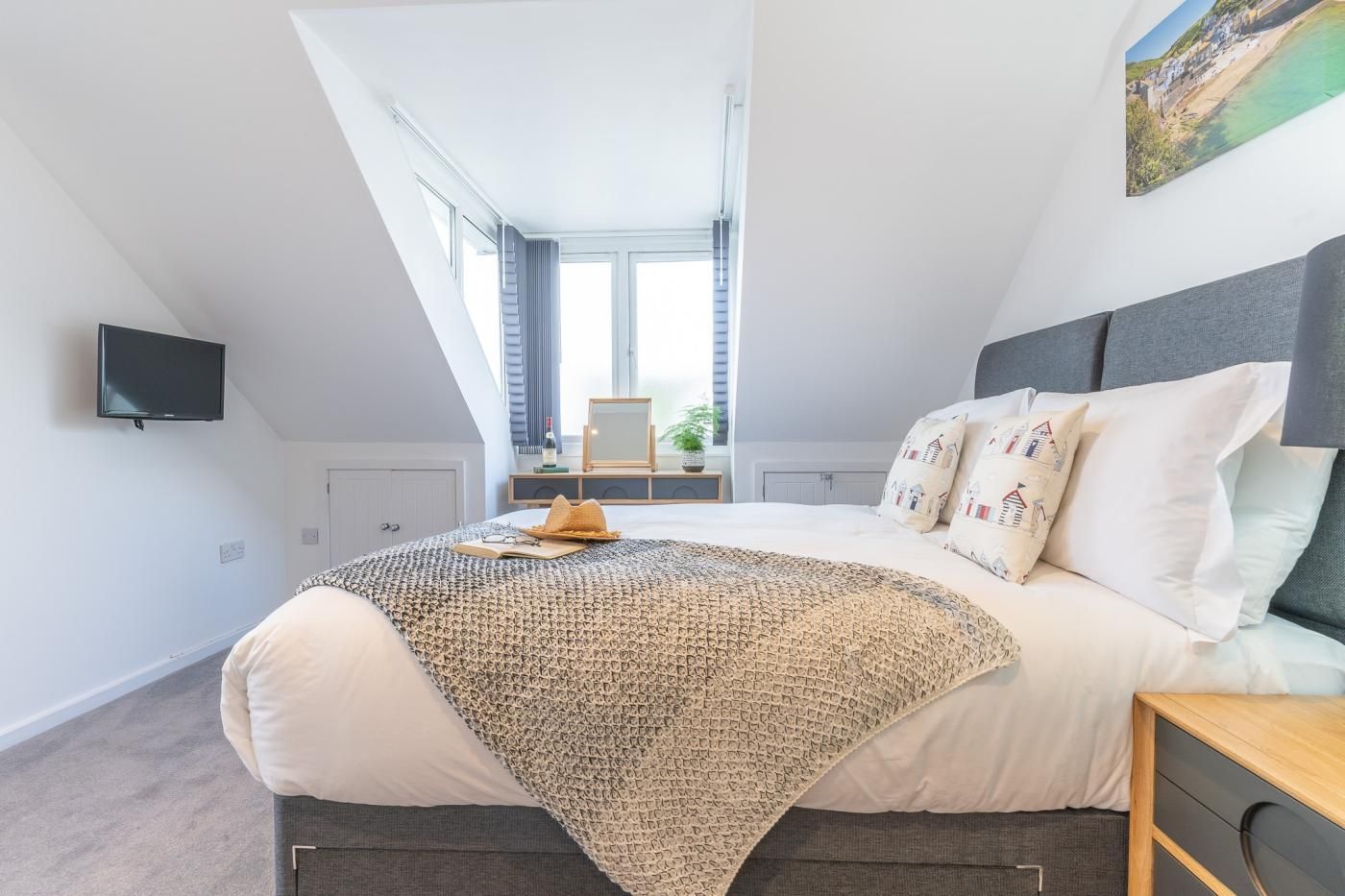 Una camera da letto moderna con un letto grande, una TV a parete e vista sull'esterno.