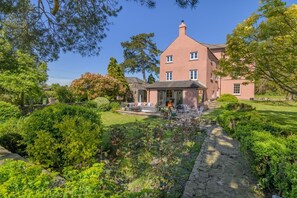 A large house with a garden, a patio with outdoor furniture, and a stone pathway. - 7 Bed in Awre (oc-b42471) (Awre)