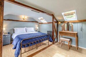 A bedroom with a bed, a wooden dresser, a mirror, and a skylight. - 1 Bed in Halesworth (oc-p44724) (Halesworth)