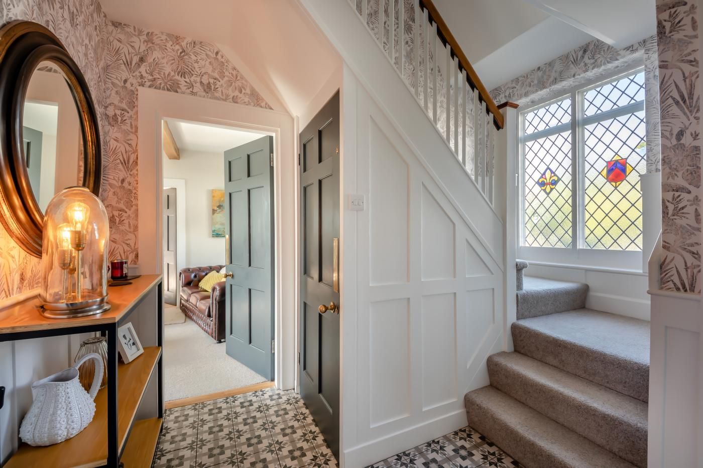 A staircase with a wooden handrail and a patterned carpet.