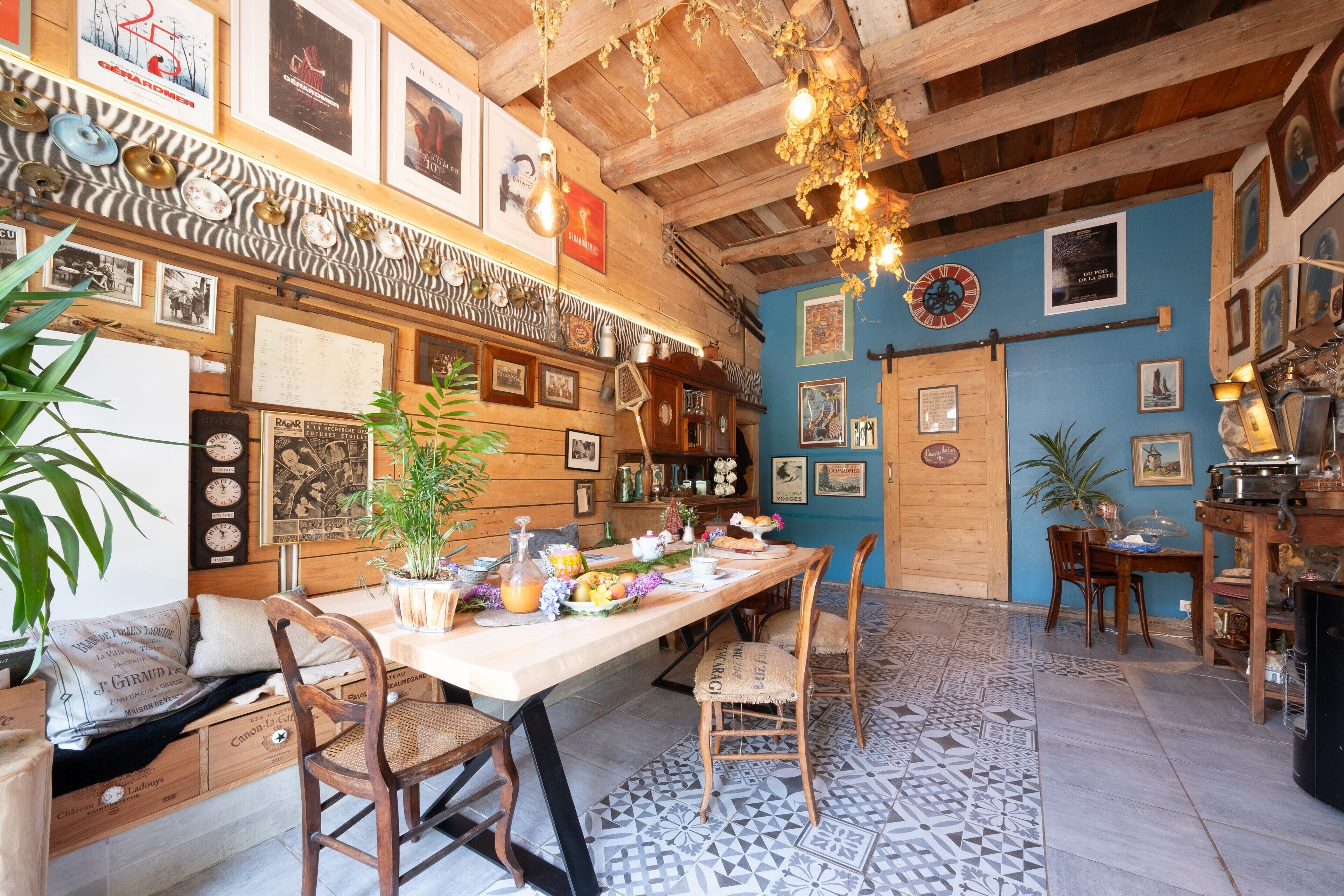 Un comedor rústico con una mesa de madera, sillas y una variedad de platos y adornos.
