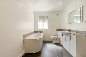 A modern bathroom with a bathtub, toilet, and sink. - 3 Bed in Croyde (oc-t44822) (Croyde)