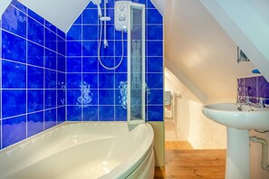 A bathroom with a bathtub, a shower, and a sink. - 1 Bed in Ruan Minor (oc-rencot) (Ruan Minor)
