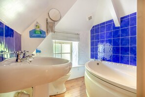 A bathroom with a large sink, a bathtub, and blue-tiled walls. - 1 Bed in Ruan Minor (oc-rencot) (Ruan Minor)