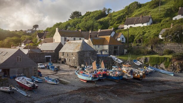 A coastal village with stone buildings, a harbor with boats, and a hillside with houses. - 1 Bed in Ruan Minor (oc-rencot) (Ruan Minor)