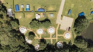 An aerial view of a campsite with tents, a covered area, and circular structures. - 1 Bed in Hanworth (oc-a43295) (Hanworth)