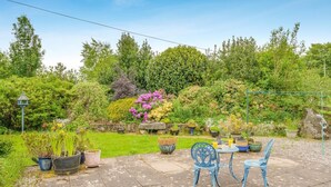 A patio with a table and chairs, surrounded by potted plants and a garden. - 3 Bed in Balmaclellan (oc-i44754) (Balmaclellan)