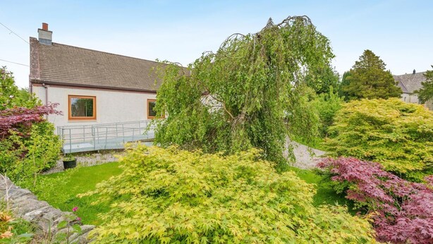 A house with a sloped roof, a visible chimney, and a small porch with a railing. - 3 Bed in Balmaclellan (oc-i44754) (Balmaclellan)