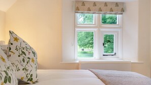 A bedroom with a bed, a window with a view of greenery, and a decorative valance. - 1 Bed in Exton (oc-e42799) (Exton)