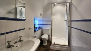 Ein Badezimmer mit Waschbecken, Toilette und Dusche.