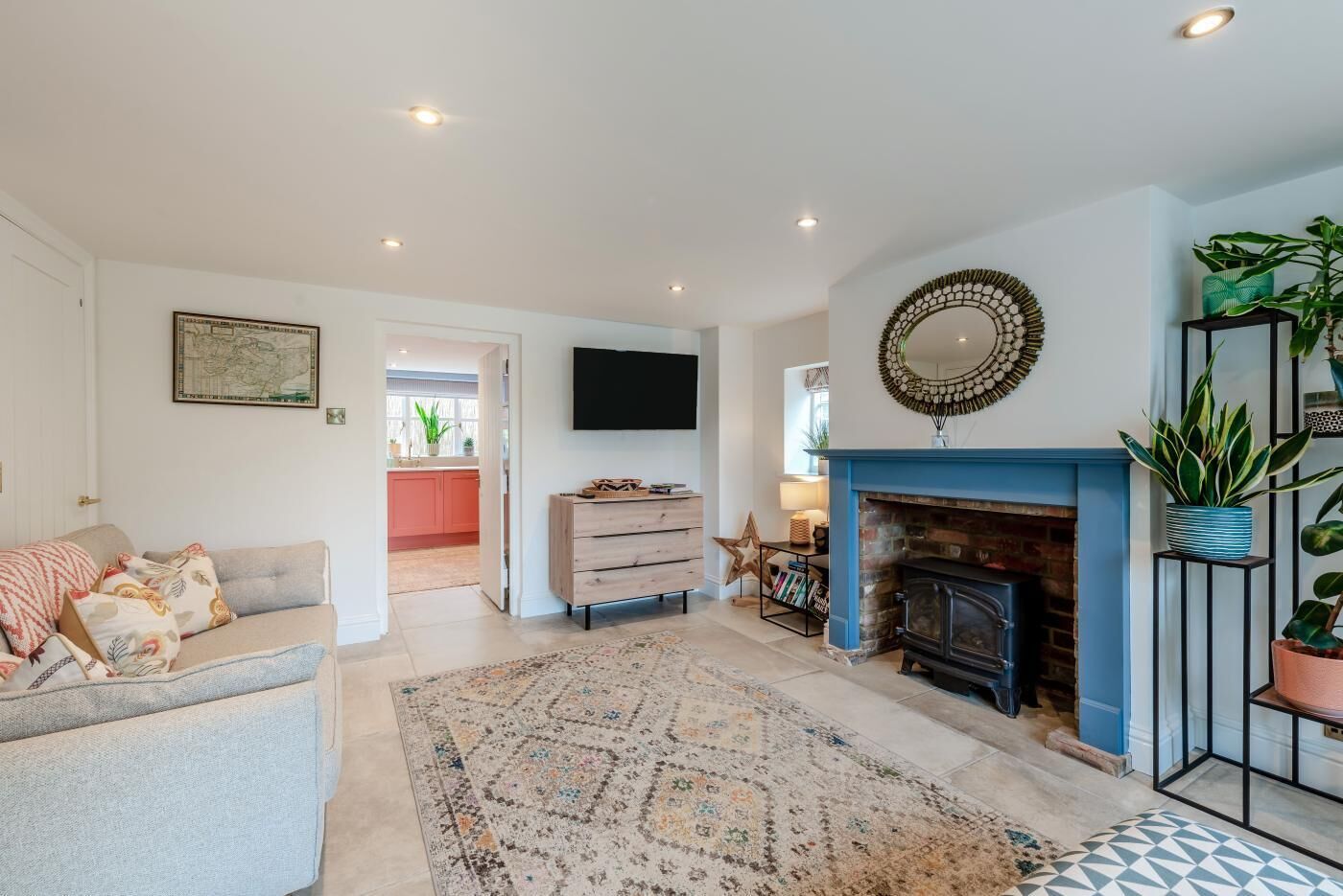 A living room with a fireplace, a sofa, a television, and a patterned rug.