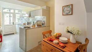 Una cocina moderna con una isla central, una mesa de comedor con sillas y un adorno en la pared.