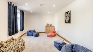 Une pièce comprenant un canapé, deux fauteuils en forme de poire, un meuble en bois et une œuvre d’art murale.