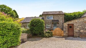 A stone house with a gravel driveway, a wooden gate, and a small garden. - 1 Bed in Tremar (oc-w44759) (Tremar)