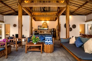 A spacious living area with wooden furniture, a sofa, and a coffee table. - Villa Nakal in Seminyak (Seminyak)
