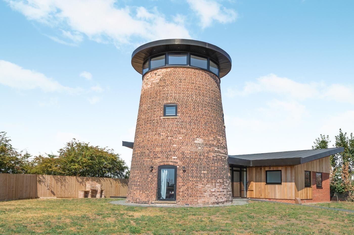 A brick tower structure with a circular top, a door, and a small window.