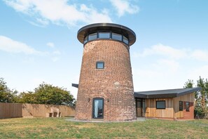 Una estructura de torres de ladrillo con una parte superior circular, una puerta y una ventana pequeña.
