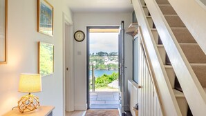 A hallway leading to a balcony with a view of a body of water and buildings. - 4 Bed in Polruan (oc-s41411) (Fowey)