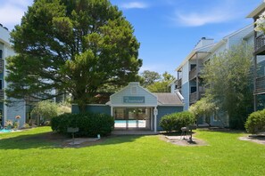 Um edifício com uma placa que diz 'The Courtyard', rodeado por vegetação e árvores.