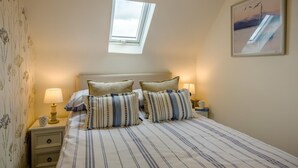A bedroom with a skylight, striped bedding, two bedside lamps, and a framed picture on the wall. - 2 Bed in Docking (oc-t44851) (Docking)