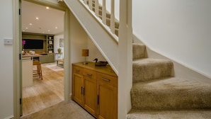 A staircase leading to a second floor, a wooden cabinet, and a kitchen area with a bar. - 2 Bed in Docking (oc-t44851) (Docking)