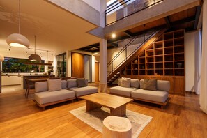 A spacious living area with a sofa set, a coffee table, and a staircase leading to an upper level. - Villa Pakuk in Kecamatan Kuta Utara (Kecamatan Kuta Utara)