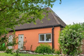 A house with a brick exterior, a tiled roof, and a garden with various plants and a bush. - 1 Bed in Beckingham (oc-b42840) (Beckingham)