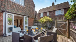 A patio with a table set for breakfast, wicker chairs, and a wooden deck. - 2 Bed in Rye (oc-f44884) (Rye)