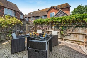 Eine Terrasse mit einem für das Frühstück gedeckten Tisch, umgeben von Korbmöbeln.