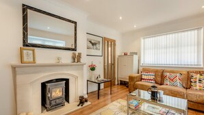 A living room with a fireplace, a sofa, a coffee table, and a large mirror. - 2 Bed in Rye (oc-f44884) (Rye)