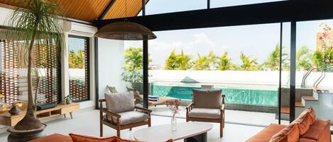 A modern interior with a large window, a pool, and a wooden ceiling.