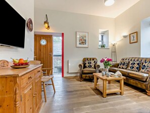 A living room with a wooden cabinet, a television, a sofa, a chair, and a coffee table. - 2 Bed in St. Austell (oc-43123) (Charlestown)