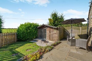 A backyard with a wooden shed, a patio table with chairs, and a lawn. - 1 Bed in Rathmell (oc-w44883) (Gisburn Forest)