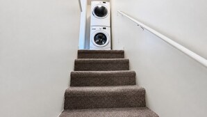 A staircase leading to a laundry area with a washing machine and dryer.