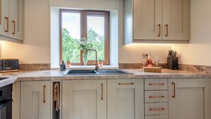Eine Küche mit einem großen Fenster, einem Spülbecken und Schränken.