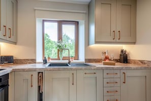 A kitchen with a large window, a sink, and cabinets. - 2 Bed in Holmbridge (oc-s44882) (Holmfirth)