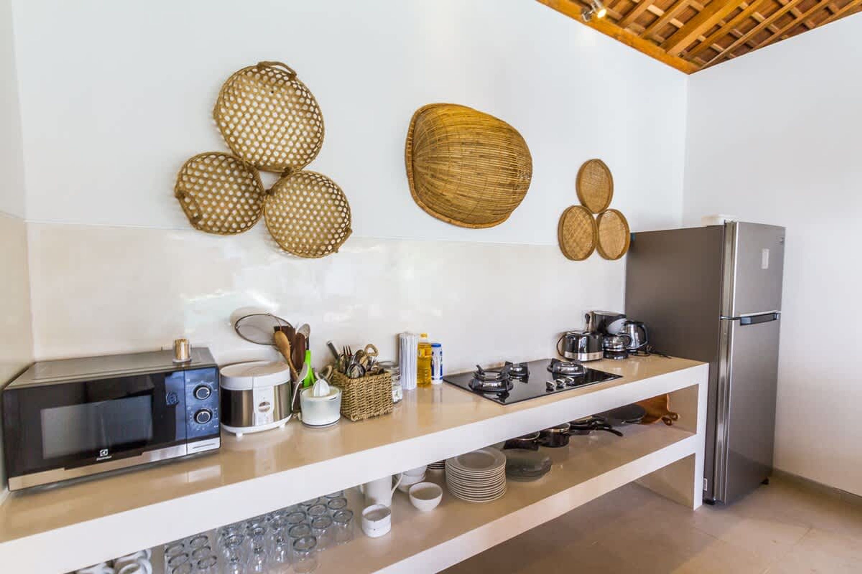 Una cocina equipada con microondas, tostadora, estufa y refrigerador.