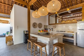 Une cuisine moderne dotée d’un îlot central, de tabourets de bar, d’un réfrigérateur et d’un distributeur d’eau.