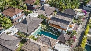 Zona residencial con varias casas, una piscina central y vegetación circundante.