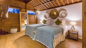 Una habitación de madera con una cama, mesitas de noche y un ventanal.