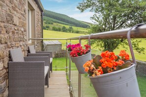 A balcony with wicker furniture and flower pots. - 1 Bed in Chaigley (oc-c44973) (Aighton, Bailey and Chaigley)