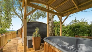 A wooden deck with a hot tub, a wooden pergola, and a black shed. - 1 Bed in Broxburn (oc-t44711) (Broxburn)