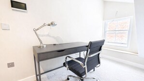 Un ufficio moderno con scrivania, sedia, lampada e una finestra vista.