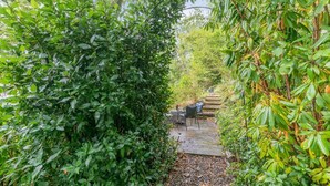 A garden pathway with a seating area and a stone wall. - 2 Bed in Swimbridge (oc-p44771) (Swimbridge)