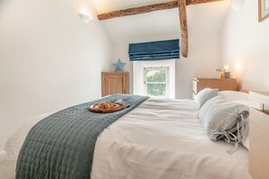 Une chambre à coucher avec un lit, une fenêtre, une tête de lit en bois, une table de chevet et une décoration en forme d’étoile.