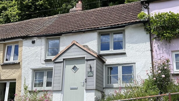 A two-story house with a grey door, multiple windows, and a visible number '19' on the door. - 2 Bed in Swimbridge (oc-p44771) (Swimbridge)