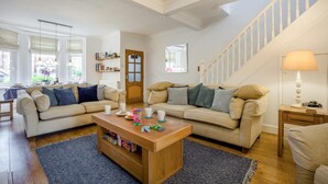 Ein Wohnzimmer mit einer Couch, einem Couchtisch und einer Treppe.